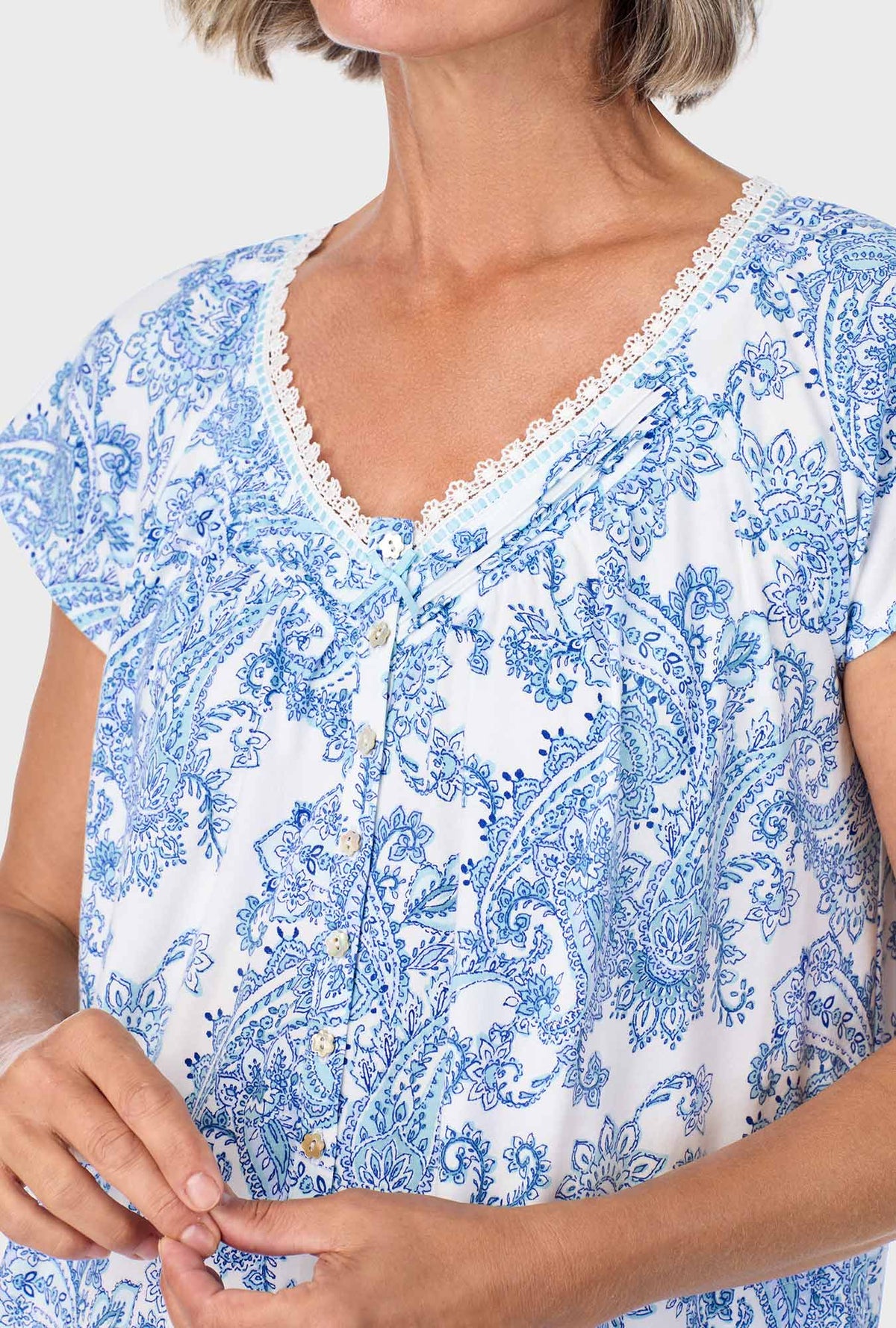 A lady wearing blue cap sleeve nightgown with cool multi paisley print.