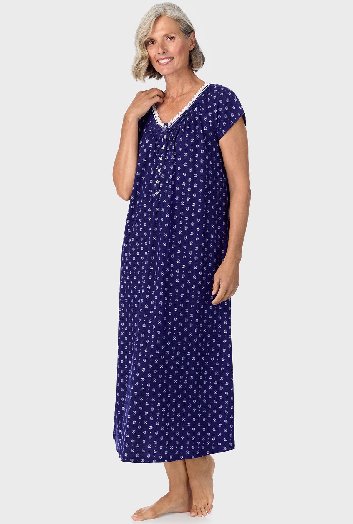 A lady wearing navy cap sleeve nightgown with navy geo print.