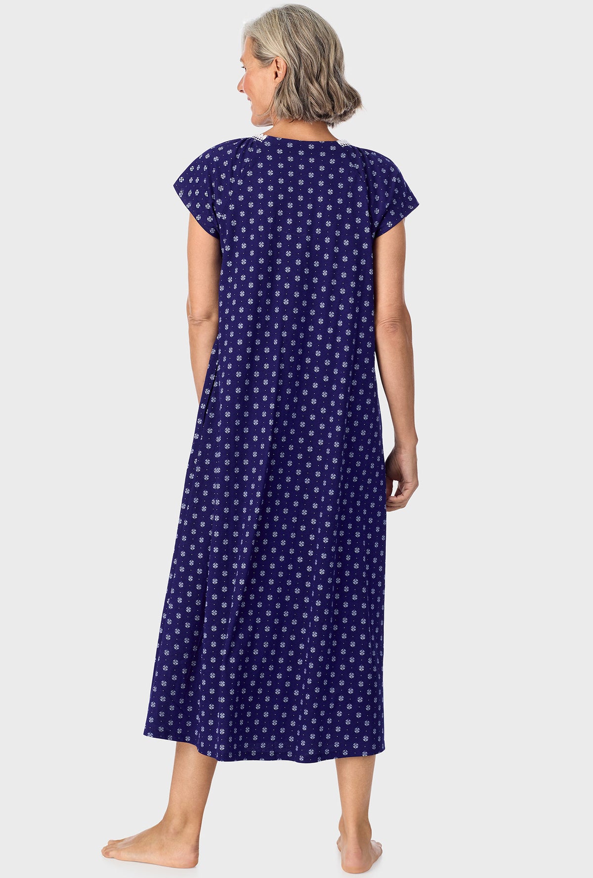 A lady wearing navy cap sleeve nightgown with navy geo print.