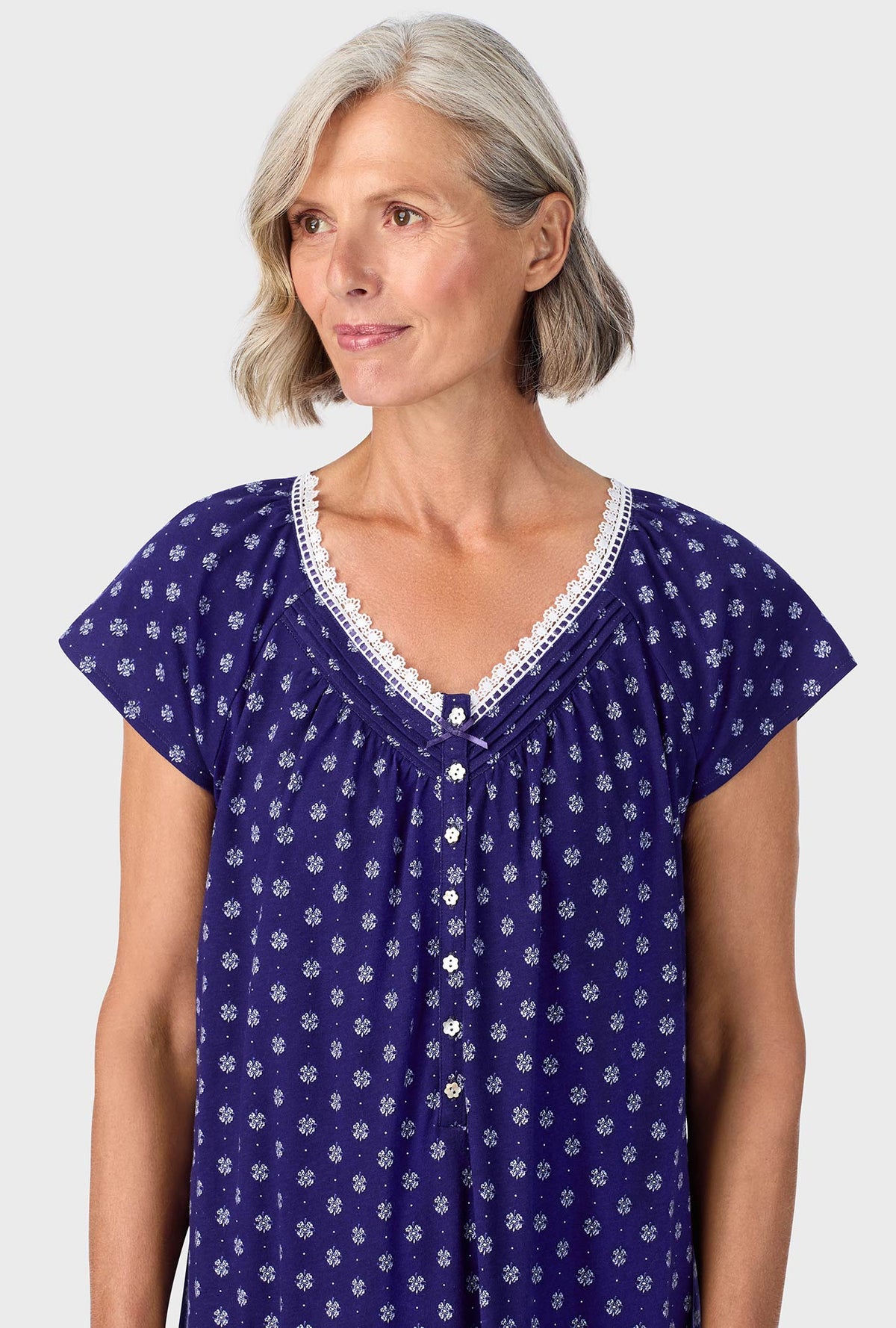 A lady wearing navy cap sleeve nightgown with navy geo print.