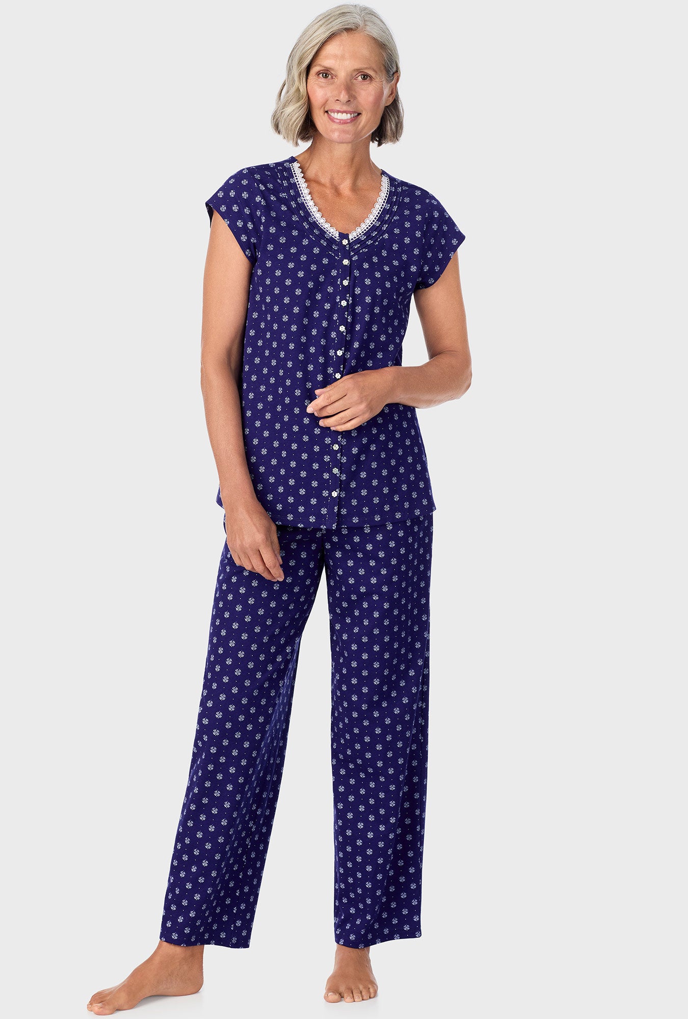 A lady wearing navy cap sleeve long pant pj set with navy geo print.