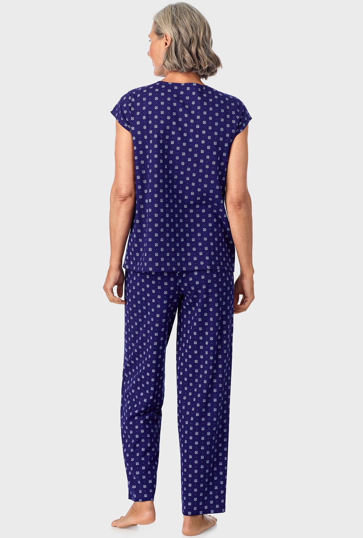 A lady wearing navy cap sleeve long pant pj set with navy geo print.